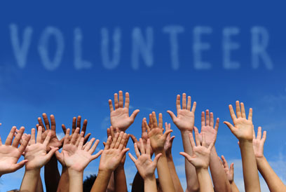 photo of people hands with the word volunteer above them
