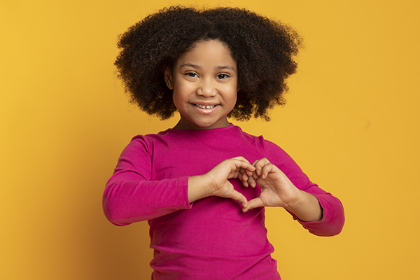 girl making heart symbol with hands