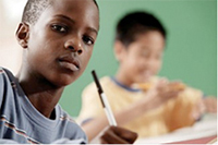 boy holding a pen in a classroom